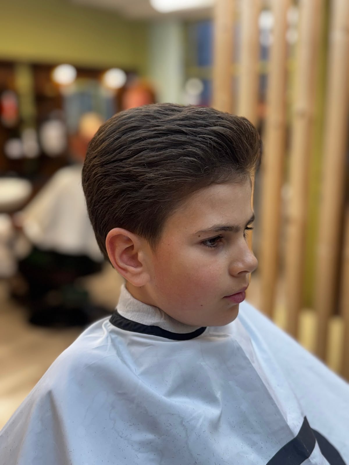 Barber cutting a client's hair in a cozy Clonakilty barbershop